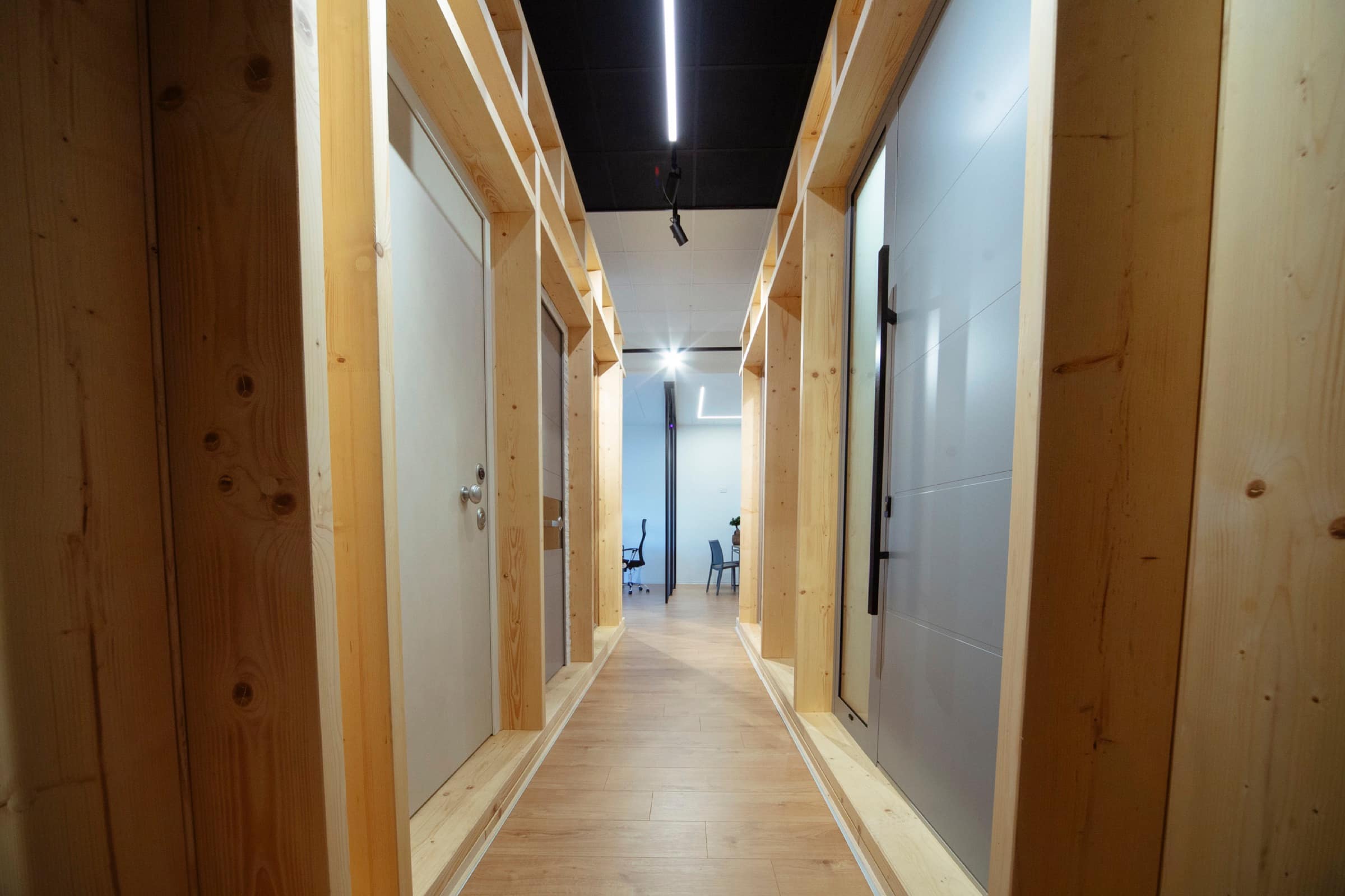 Percorso espositivo dell'Atelier127 tra pareti in legno e serramenti