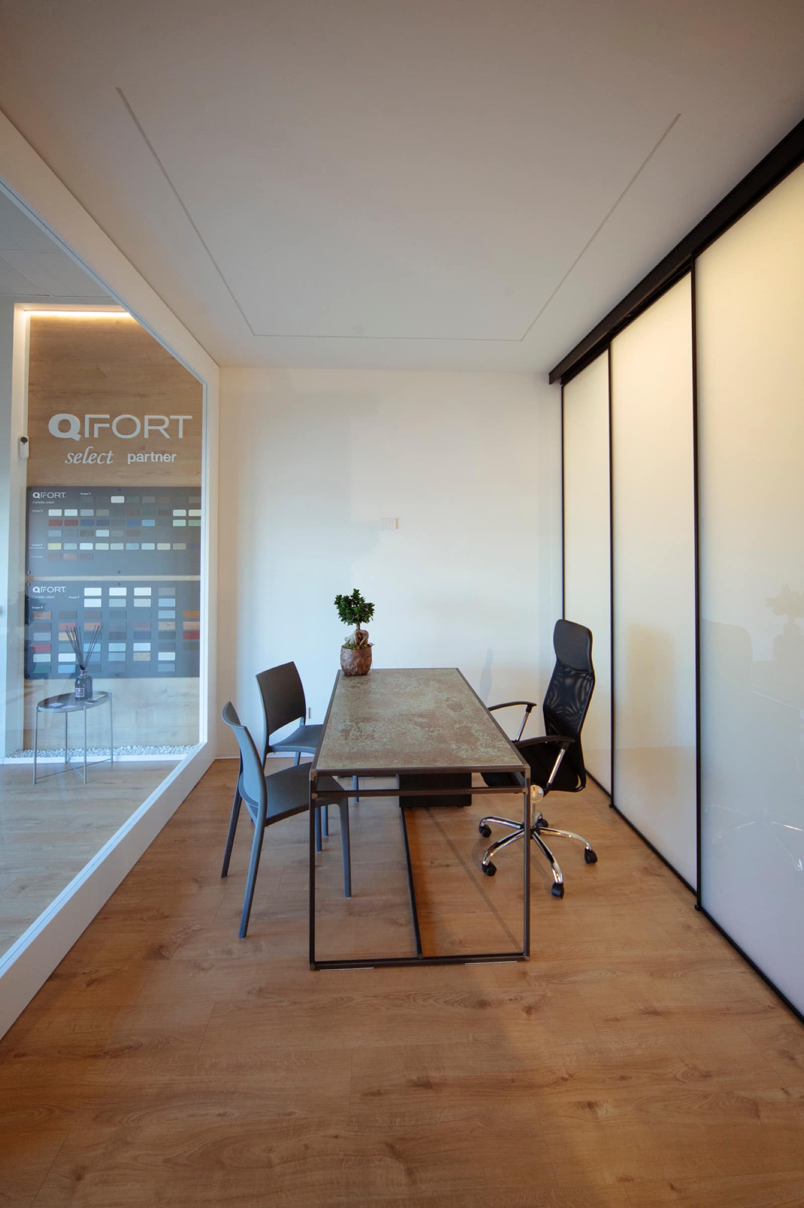 Sala riunioni dell'Atelier127 con tavolo in legno e campionario QFort